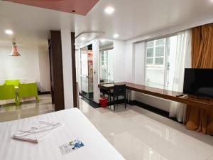 a room with a bed and a desk and a window at The Color Kata in Kata Beach
