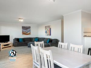 een woonkamer met een tafel en stoelen en een bank bij Beautiful Sea & Lake Views - Sleeps 12! in Encounter Bay