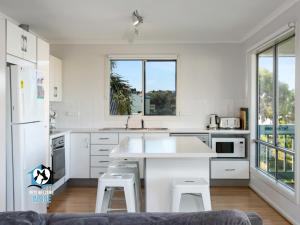 een keuken met witte apparatuur en een groot raam bij Beautiful Sea & Lake Views - Sleeps 12! in Encounter Bay