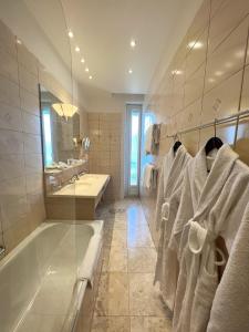 y baño con bañera, lavabo y toallas. en Hotel Eden Palace au Lac en Montreux