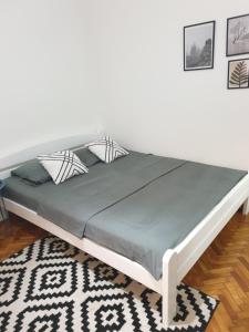 a large bed in a room with a white wall at Apartman Park Jagodina-studio u centru grada in Jagodina