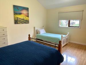 1 dormitorio con 2 camas individuales y ventana en Ronald's Roost farmstay Kangaroo Island, en Wisanger