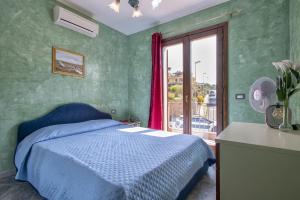 カステルサルドにあるAppartamento vista mareのベッドルーム(青いベッド1台、窓付)