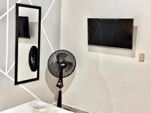 a white room with a fan and a tv at Habitación VIP in Ibagué