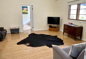 una sala de estar con una alfombra de piel negra en el suelo en Ronald's Roost farmstay Kangaroo Island, en Wisanger