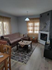 a living room with a couch and a fireplace at Primoula Grammou 1450 in Néa Kotýli