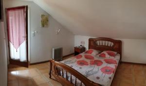 Un dormitorio con una cama con flores rojas. en Le tibouchina, en Le Tampon
