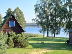 a cabin with a view of a lake at Poilsio nameliai Pasartele in Kavoliai +6 photos