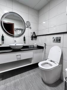 a bathroom with a toilet and a sink and a mirror at Howard Johnson Bur Dubai in Dubai