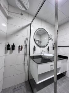 a white bathroom with a sink and a mirror at Howard Johnson Bur Dubai in Dubai