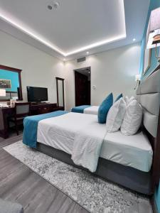 1 dormitorio con 1 cama grande con almohadas azules y blancas en Howard Johnson Bur Dubai, en Dubái