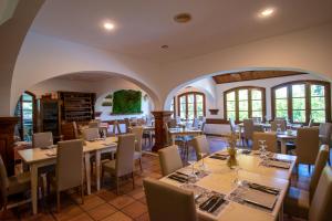 un restaurante con mesas, sillas y ventanas en Hotel del Carmen, en Prado del Rey