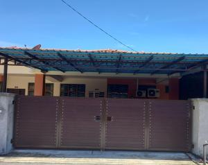 a pair of garage doors in front of a house at D'tasek Homestay Gua Musang in Gua Musang