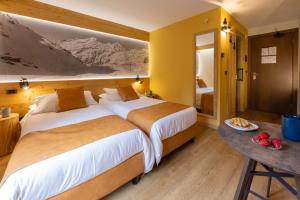 Łóżko lub łóżka w pokoju w obiekcie Hotel Petit Tournalin