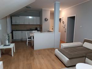 a living room and kitchen with a couch and a table at Apartman Mima in Borča