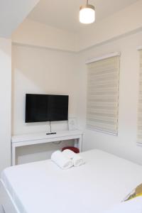 biały pokój z 2 łóżkami i telewizorem w obiekcie LuxeCara Guest House w mieście Lipa