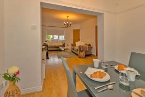 a living room with a table and a couch at Finest Retreats - DeBarnes House in Solihull