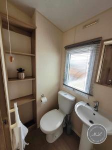 a bathroom with a white toilet and a sink at The Meadows 34 - Golden Palm Resort, pet friendly, WiFi & bed linen - Meadow Lakes Caravan & Lodge Hire in Chapel Saint Leonards +4 photos