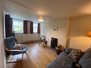 uma sala de estar com um sofá e uma cadeira em Sandholme Cottage - Pateley Bridge em Pateley Bridge