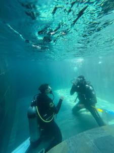 two people in the water next to a diver at Maison Ylang Dive Center in Nosy Be