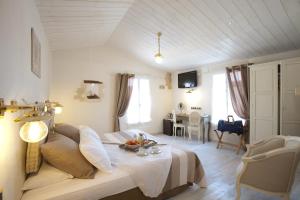 a room with a bed and a table in it at Chambre d'hôtes Hôte des Portes Île de Ré in Les Portes