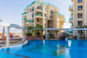 una piscina frente a algunos edificios en YalaRent Golf Residence 3BR apt in luxury complex with pool, en Eilat