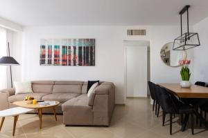 エイラットにあるYalaRent Golf Residence 3BR apt in luxury complex with poolのソファとテーブルのあるリビングルーム