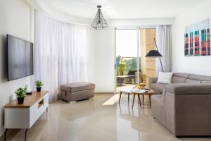 エイラットにあるYalaRent Golf Residence 3BR apt in luxury complex with poolのソファとテーブルのあるリビングルーム