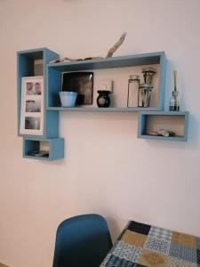 a blue shelf on a wall with a blue chair at Albisola, a 50 m dal mare in Albisola Superiore