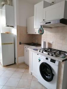 a kitchen with a stove and a washing machine at Albisola, a 50 m dal mare in Albisola Superiore