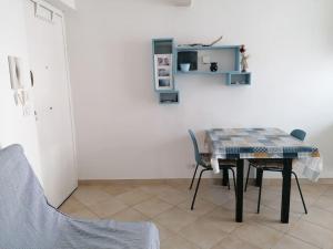 a table and chairs in a room with a white wall at Albisola, a 50 m dal mare in Albisola Superiore