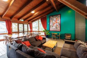 a living room with couches and a table and chairs at YHA Thredbo in Thredbo