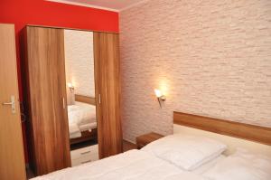 a bedroom with a large mirror and a bed at Ferienwohnungen Appartements - Ferienhaus Müritzstern in Marienfelde +16 photos