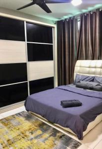 a bedroom with a purple bed with a ceiling fan at Harmoni Homes Vista Alam in Shah Alam