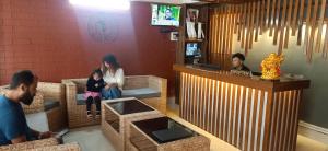 un grupo de personas sentadas en sillas en un bar en Hotel Deysal Noora en Bomdila