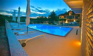 a large swimming pool with lounge chairs and umbrellas at Agriturismo "Le Giustizie" in Agliano Terme