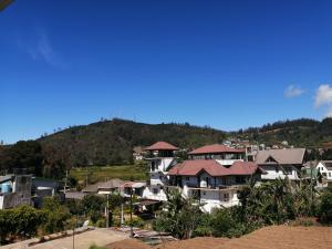 un groupe de maisons avec une montagne en arrière-plan dans l'établissement Roseberry Villa, à Nuwara Eliya