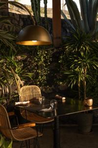 une table et des chaises dans une pièce ornée de plantes dans l'établissement Santo Pure Oia Suites & Villas, à Oia