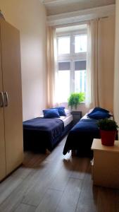 two beds in a room with a window at Urban Nest Apartments Gertrudy 7 in Krakow