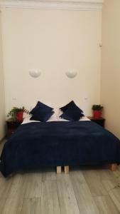 a bed with a blue blanket on top of it at Urban Nest Apartments Gertrudy 7 in Krakow