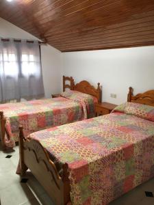 a bedroom with two beds and a wooden ceiling at CASA NECHO 