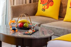 a table with a bowl of fruit and a toy on it at Midtown Shangri-La, Hangzhou - around 5 minutes walking distance to West Lake in Hangzhou