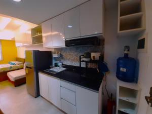 a kitchen with white cabinets and a black counter top at 1809 Sunvida Tower Condo across SM City Cebu in Cebu City