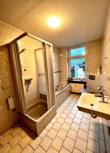 un bagno con doccia, lavandino e vasca di Mitten im Herzen a Schönebeck