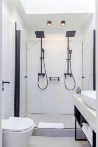 a white bathroom with a shower and a toilet at Emil Balaban Luxury Apart-Hotel in Bucharest