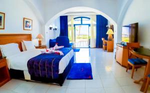 ヌウェイバにあるTIME Coral Nuweiba Resortのベッド、テーブル、キッチンが備わるホテルルームです。