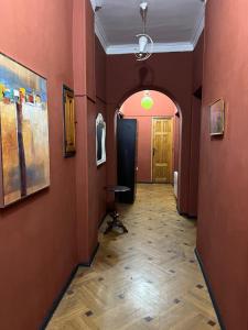 um corredor com paredes vermelhas e piso de madeira em New hostel in Melikishvili em Tbilisi