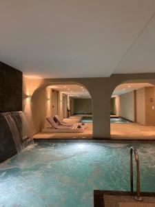 a large swimming pool with a waterfall in a hotel at Mythical Coast Wellness Retreat in Mytilini