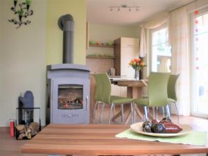 Una sala de estar con chimenea y una mesa y sillas. en Ferienwohnungen Appartements - Ferienhaus Müritztraum, en Marienfelde