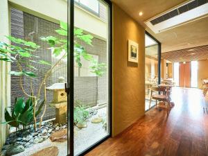 una stanza con una grande porta a vetri con una pianta di 枳殻の杜 Kikoku no mori a Kyoto